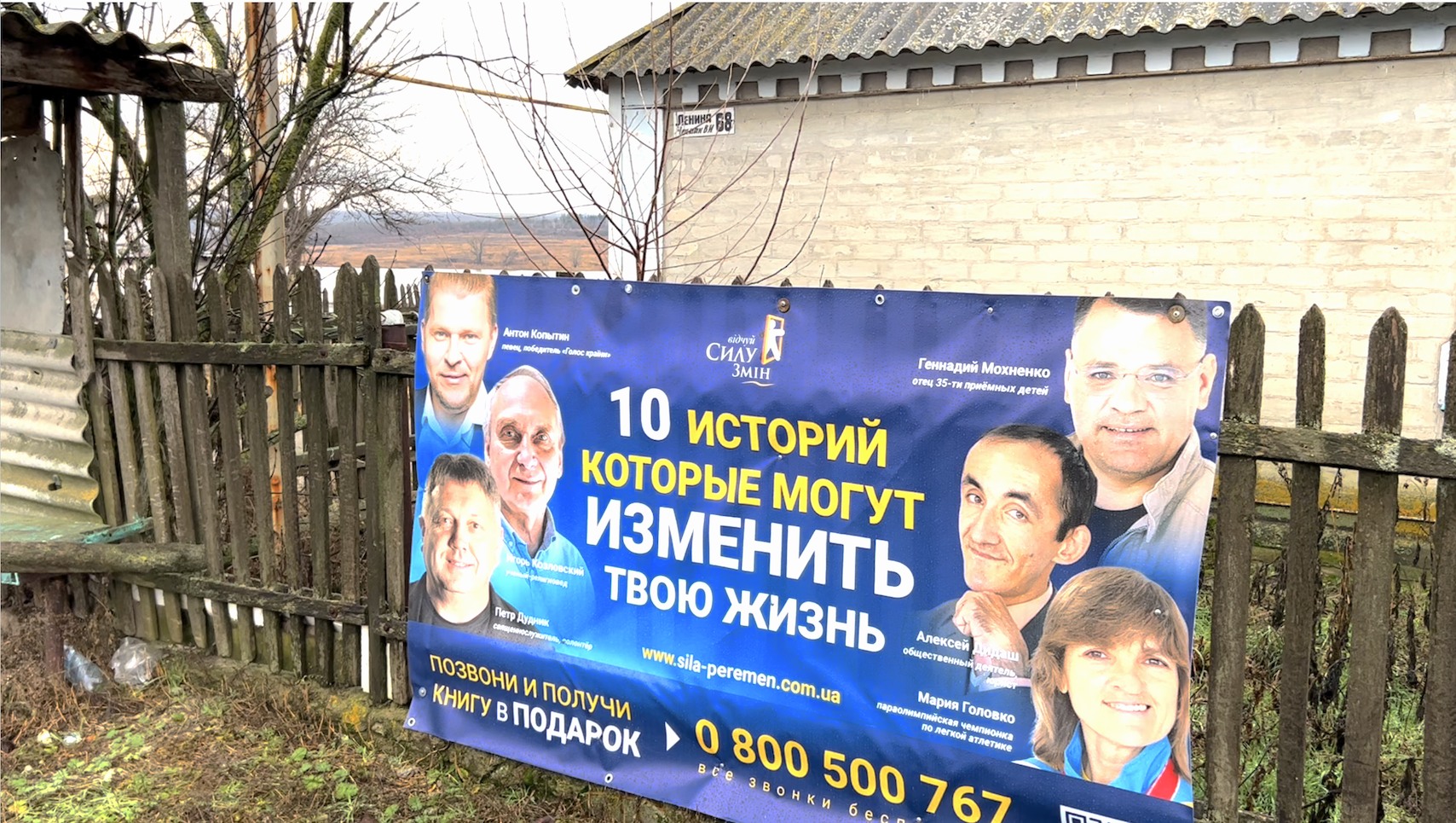The village of Chermalyk in the conflict zone. A campaign ad on the fence tells of God's life-changing power through the testimony of 10 highly recognizable people.