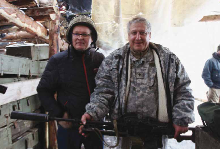 Feb19Web9 GCM Ministries has provided broilers from the chicken farm, to children and to the soldiers in the conflict zone. The most important part of this trip was prayer. We prayed for and encouraged soldiers at our every stop. Photo: Chaplain Albert checks the weight of a heavy sniper rifle.