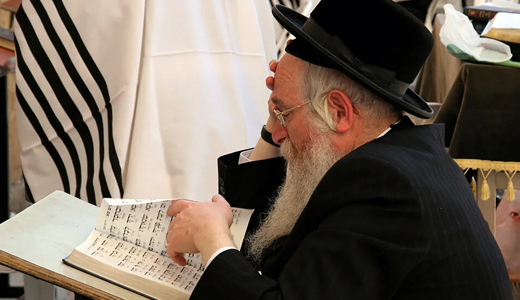A Jewish man reads from a Hebrew prayer book, representing the people GCMM hopes to reach with Gospel resources in Israel.